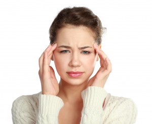 A young woman with a headache holding head