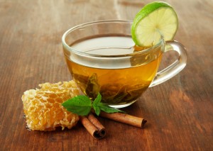 Transparent cup of green tea with honey and cinnamon