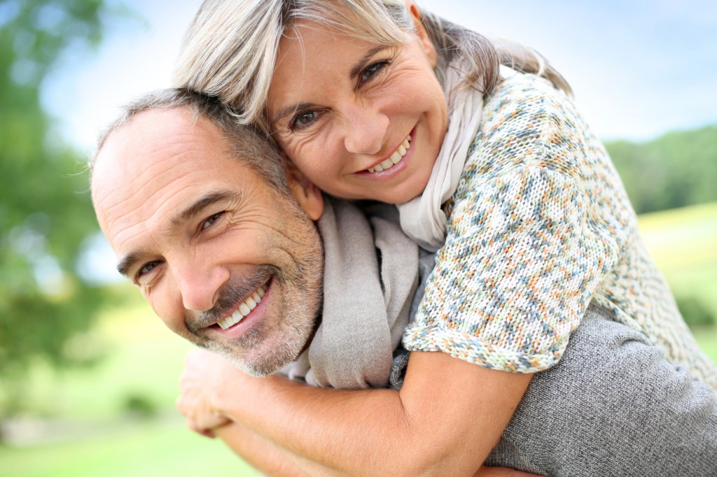 Senior man giving piggyback ride to woman