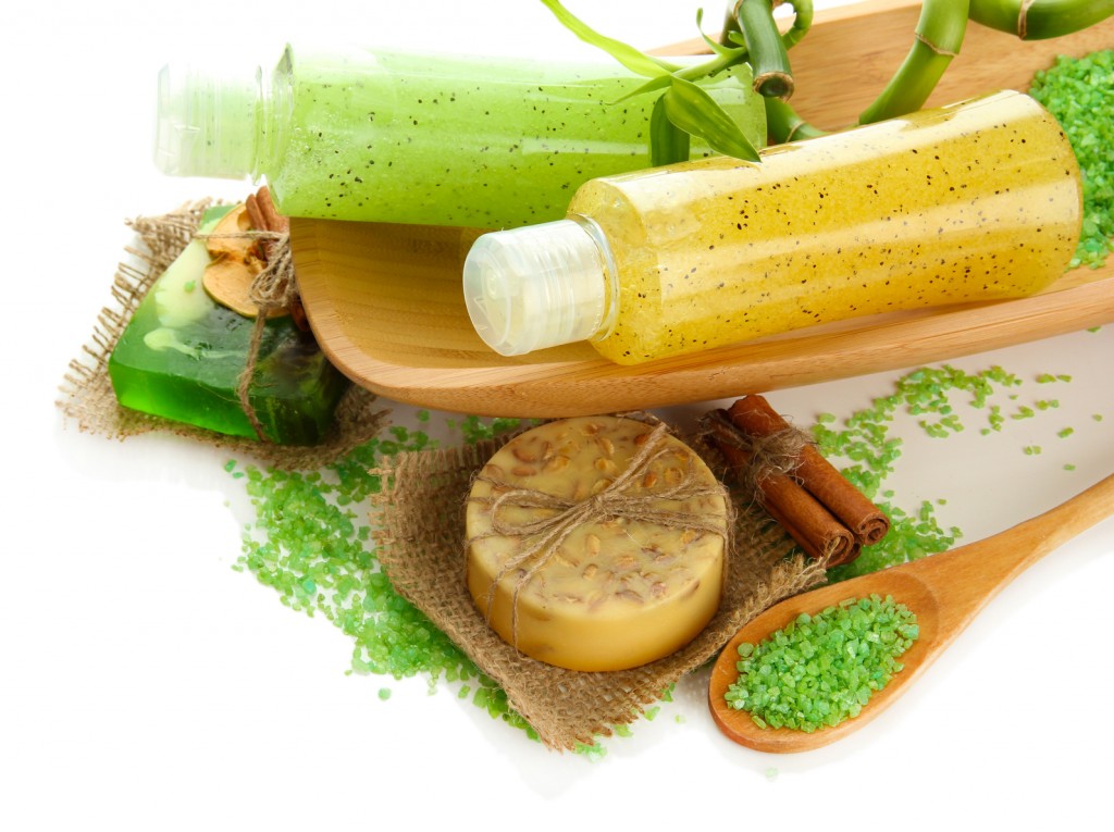 Bottles with scrub and hand-made soap, isolated on white