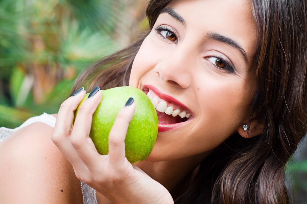 Portrait of a young woman's face eating an apple