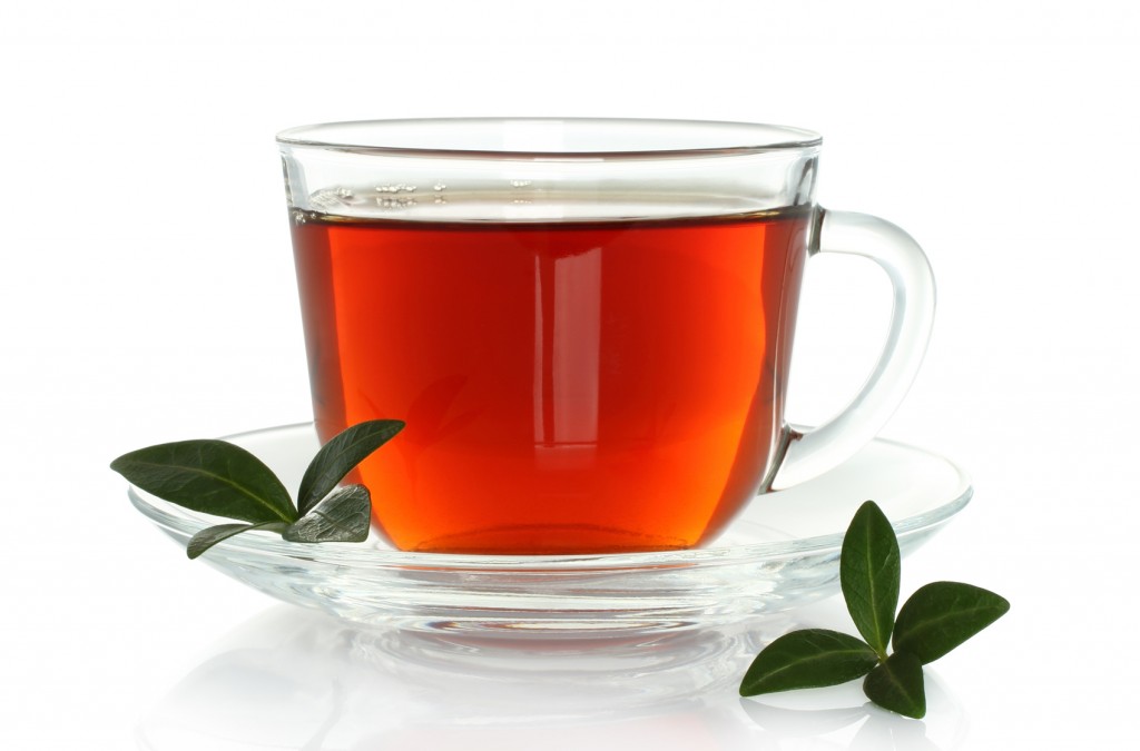 Cup of tea with green leaves