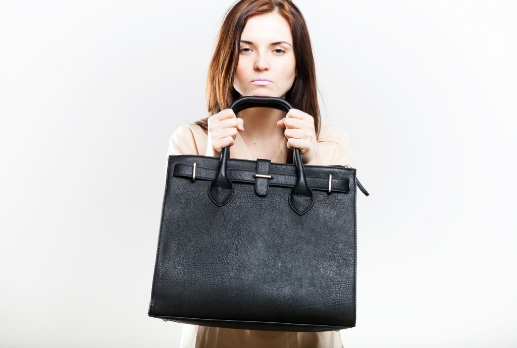 Angry young woman with black bag