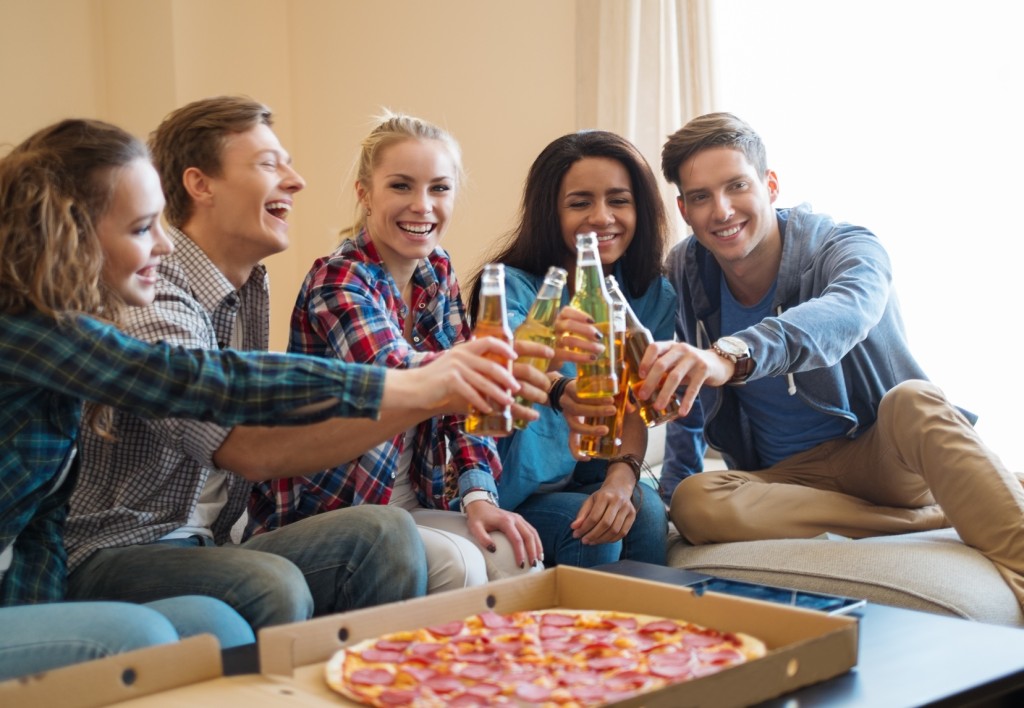 Group of young friends celebrating in home interior