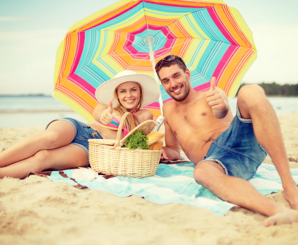 smiling couple sunbathing on the beach
