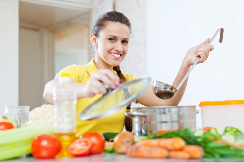 woman cooking  vegetarian food in saucepan